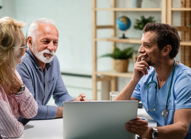 3 people discussing while looking at laptop screen