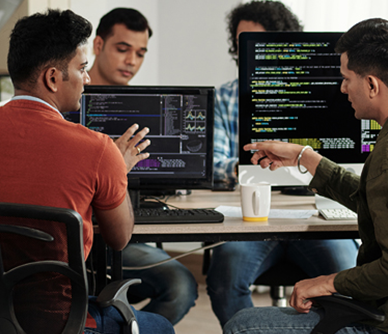 Two pople discussing code on laptop