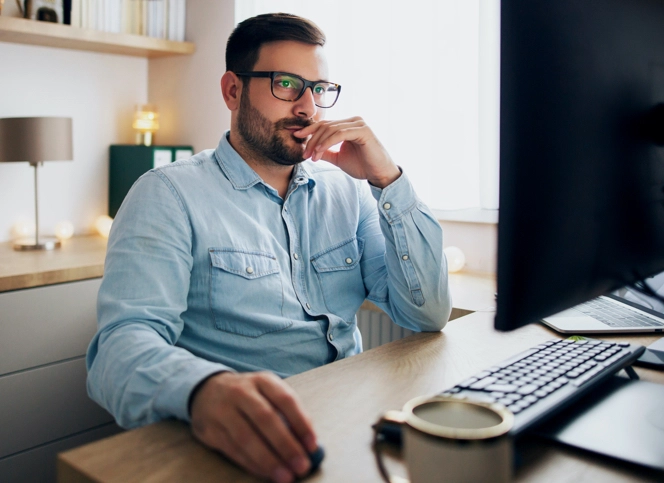 A man in deep thought thinking for a solution while looking at the screen