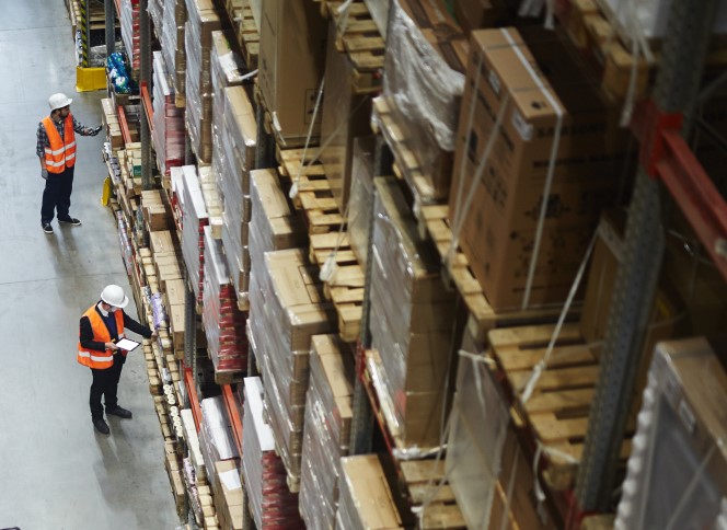 Top view of two employees checking inventory on shelves in warehouse