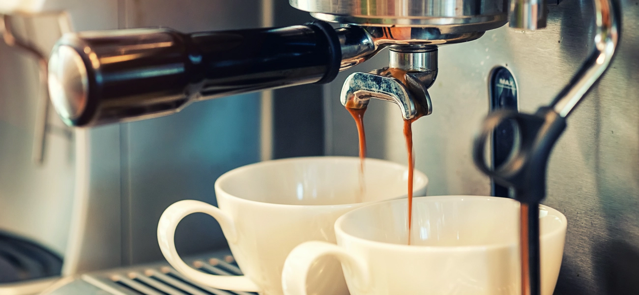 Picture with focus on coffee espresso machine pouring coffee in cups