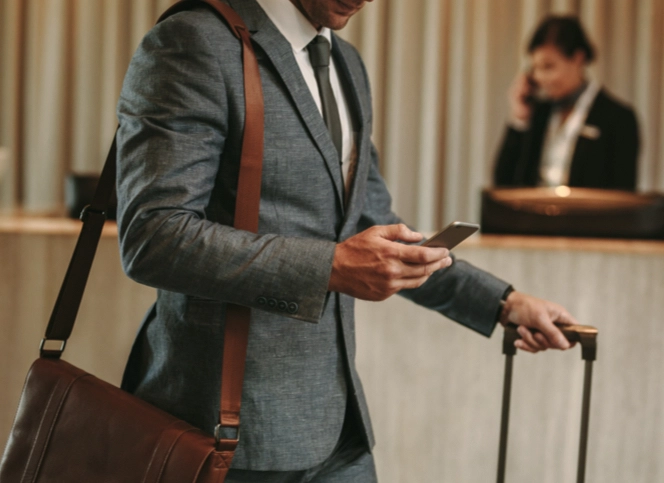 Man in office suit at hotel reception checking his phone